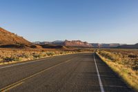 the highway through the desert is quiet and empty of traffic during the day light or setting