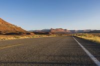 the highway through the desert is quiet and empty of traffic during the day light or setting