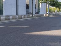 a man riding a red skateboard down a quiet street in front of a tall white building