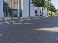 a man riding a red skateboard down a quiet street in front of a tall white building