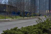 an empty street with no one on it and trees in the distance in front of some buildings