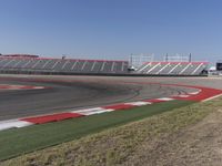 an empty track at a motorsports club with some red and white stripeing on it