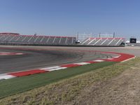 an empty track at a motorsports club with some red and white stripeing on it