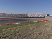 an empty track at a motorsports club with some red and white stripeing on it