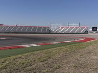 an empty track at a motorsports club with some red and white stripeing on it