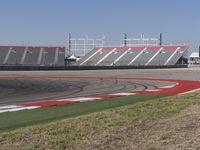 an empty track at a motorsports club with some red and white stripeing on it