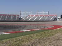 an empty track at a motorsports club with some red and white stripeing on it