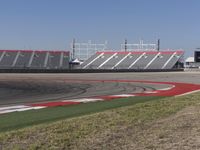 an empty track at a motorsports club with some red and white stripeing on it