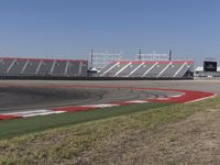 an empty track at a motorsports club with some red and white stripeing on it