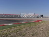 an empty track at a motorsports club with some red and white stripeing on it