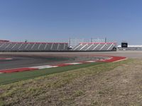 an empty track at a motorsports club with some red and white stripeing on it