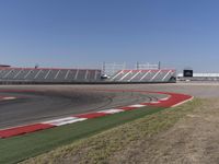 an empty track at a motorsports club with some red and white stripeing on it