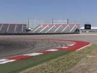 an empty track at a motorsports club with some red and white stripeing on it