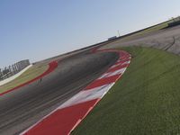 an empty track at a motorsports club with some red and white stripeing on it