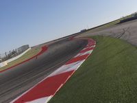 an empty track at a motorsports club with some red and white stripeing on it