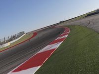 an empty track at a motorsports club with some red and white stripeing on it