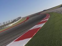 an empty track at a motorsports club with some red and white stripeing on it