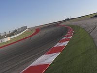 an empty track at a motorsports club with some red and white stripeing on it