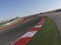 an empty track at a motorsports club with some red and white stripeing on it