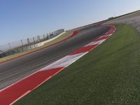 an empty track at a motorsports club with some red and white stripeing on it