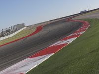 an empty track at a motorsports club with some red and white stripeing on it