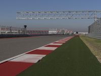 an empty track at a motorsports club with some red and white stripeing on it