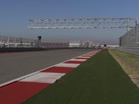 an empty track at a motorsports club with some red and white stripeing on it