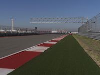 an empty track at a motorsports club with some red and white stripeing on it