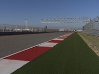 an empty track at a motorsports club with some red and white stripeing on it