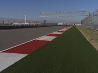 an empty track at a motorsports club with some red and white stripeing on it