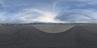 the 360 - view camera shows the ground and mountains in the background as clouds move overhead