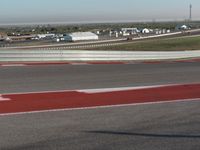 an empty track at a motorsports club with some red and white stripeing on it