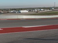 an empty track at a motorsports club with some red and white stripeing on it