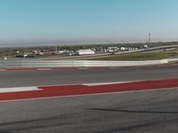 an empty track at a motorsports club with some red and white stripeing on it