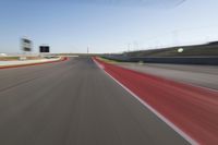 a picture of a race track with cars passing by on it as the driver speeds on