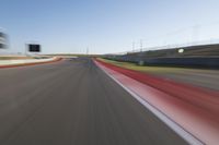 a picture of a race track with cars passing by on it as the driver speeds on