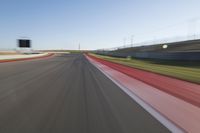 a picture of a race track with cars passing by on it as the driver speeds on