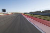 a picture of a race track with cars passing by on it as the driver speeds on