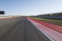 a picture of a race track with cars passing by on it as the driver speeds on