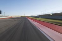 a picture of a race track with cars passing by on it as the driver speeds on