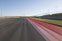 a picture of a race track with cars passing by on it as the driver speeds on