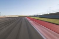 a picture of a race track with cars passing by on it as the driver speeds on