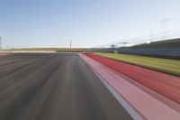 a picture of a race track with cars passing by on it as the driver speeds on