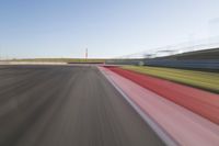 a picture of a race track with cars passing by on it as the driver speeds on