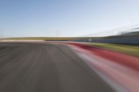 a picture of a race track with cars passing by on it as the driver speeds on