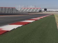 an empty track at a motorsports club with some red and white stripeing on it