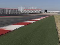 an empty track at a motorsports club with some red and white stripeing on it