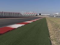 an empty track at a motorsports club with some red and white stripeing on it