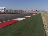 an empty track at a motorsports club with some red and white stripeing on it