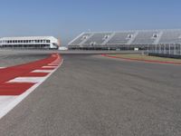 an empty track at a motorsports club with some red and white stripeing on it